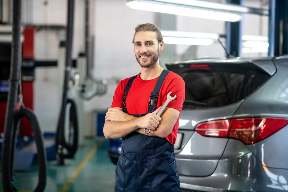 Ford Service Tips from Luv Ford - Service Technician wearing red shirt standing in shop ready to repair